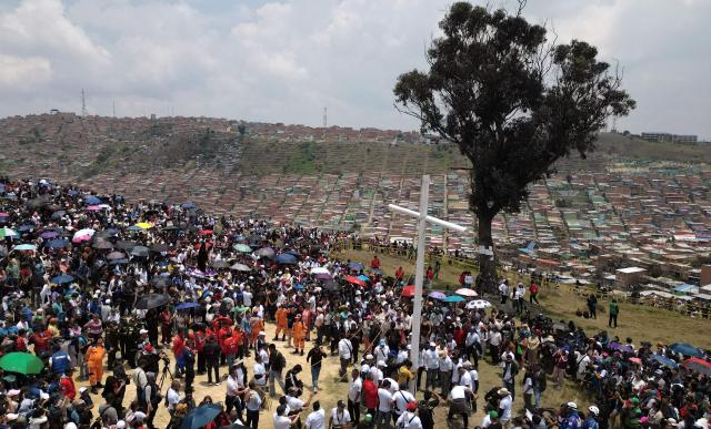 Catholic faithfuls lift a cross during the Via Crucis procession as part of Good Friday celebrations at the Tree of Life in Ciudad Bolivar, south Bogota on April 3, 2026. (Photo by Raul ARBOLEDA / AFP)