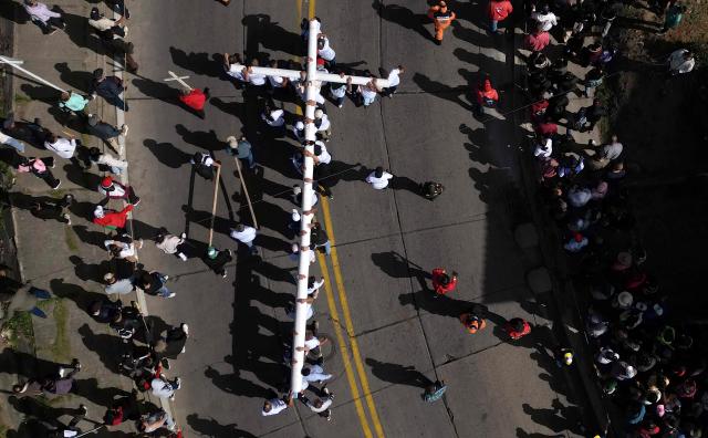 Aerial view of catholic faithfuls carrying a cross during the Via Crucis procession as part of Good Friday celebrations at the Tree of Life in Ciudad Bolivar, south Bogota on April 3, 2026. (Photo by Raul ARBOLEDA / AFP)