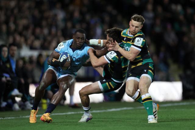 Castres' Cameroonian wing Christian Ambadiang pushes away Northampton Saints' English full-back George Furbank (C) and Northampton Saints' English Rory Hutchinson (R) during the European Rugby Champions Cup round of 16 rugby union match, between Northampton Saints and Castres Olympique at Franklin's Gardens in Northampton, central England, on April 3, 2026. (Photo by Darren Staples / AFP)
