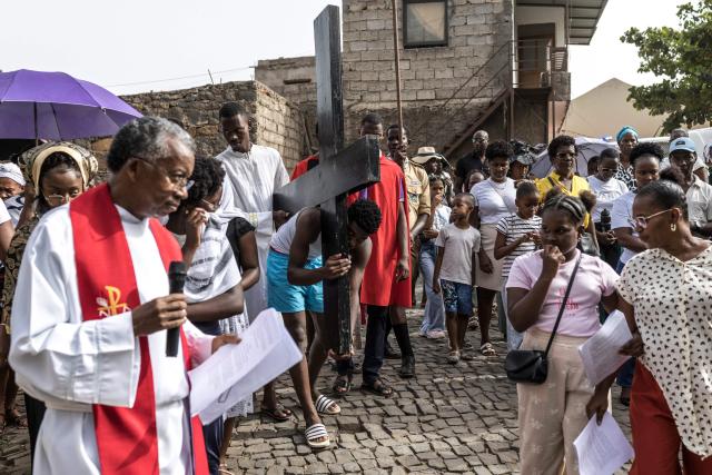 A young man carries a cross as he portrays Jesus Christ during a Good Friday Way of the Cross procession in Cidade Velha, Cape Verde, on April 3, 2026. The city was founded in 1462 by Portuguese traders and was the first colonial outpost in the tropics. Formerly known as Ribeira Grande, the town has a rich historical heritage including Our Lady of the Rosary, a church built in 1495 by Portuguese settlers. The town became a UNESCO World Heritage Site in 2009. (Photo by PATRICK MEINHARDT / AFP)