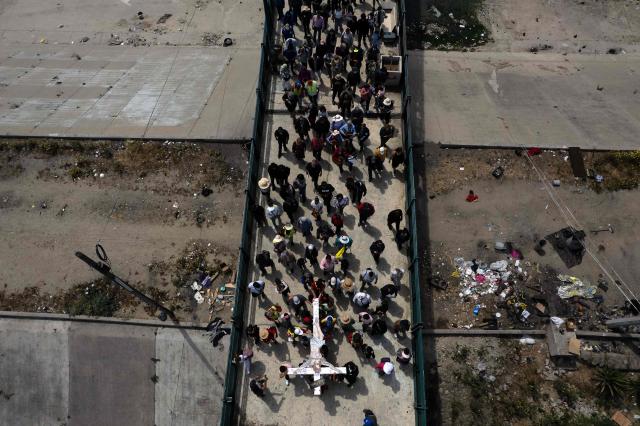 This aerial view shows Catholic faithful, migrants, and advocates participating in the Migrant Walk of the Cross as part of the Holy Week celebrations in Tijuana, Baja California state, Mexico on April 3, 2026. (Photo by Guillermo Arias / AFP)