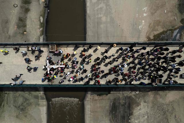 This aerial view shows Catholic faithful, migrants, and advocates participating in the Migrant Walk of the Cross as part of the Holy Week celebrations in Tijuana, Baja California state, Mexico on April 3, 2026. (Photo by Guillermo Arias / AFP)