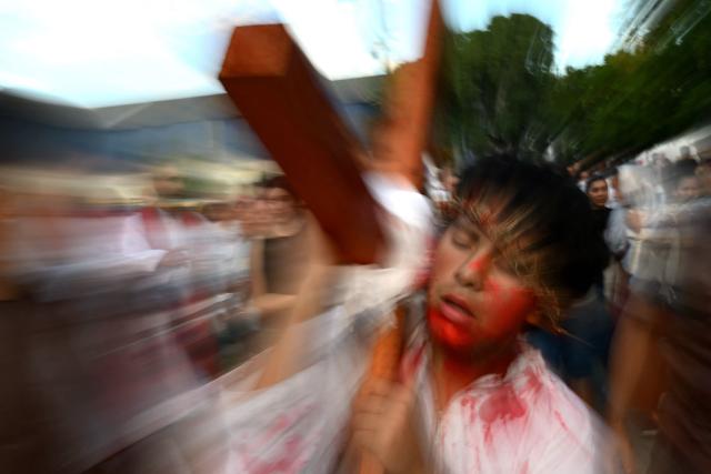 A youngster enacts the Passion of Jesus Christ during a procession marking the Way of the Cross on Good Friday at the Padre Carlos Mujica shantytown (known as Villa 31) in Buenos Aires on April 3, 2026. (Photo by Luis ROBAYO / AFP)