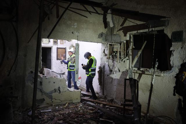 Israeli security forces and first responders gather at the site of an Iranian strike that hit a residential building in Rosh HaAyin, Israel, on April 4, 2026. (Photo by Jack GUEZ / AFP) / 
