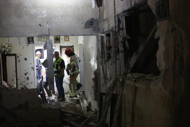 Israeli security forces and first responders gather at the site of an Iranian strike that hit a residential building in Rosh HaAyin, Israel, on April 4, 2026. (Photo by Jack GUEZ / AFP) / 