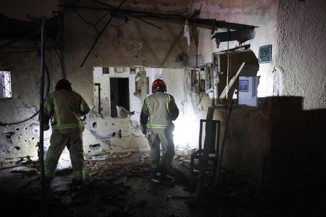 Israeli security forces and first responders gather at the site of an Iranian strike that hit a residential building in Rosh HaAyin, Israel, on April 4, 2026. (Photo by Jack GUEZ / AFP) / 