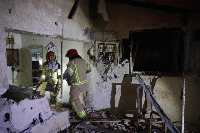 Israeli security forces and first responders gather at the site of an Iranian strike that hit a residential building in Rosh HaAyin, Israel, on April 4, 2026. (Photo by Jack GUEZ / AFP) / 