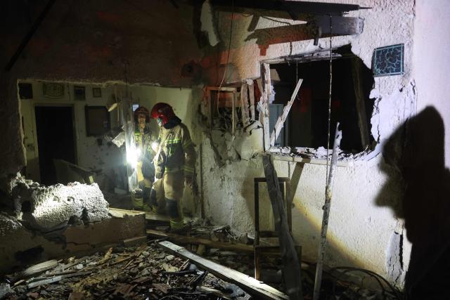 Israeli security forces and first responders gather at the site of an Iranian strike that hit a residential building in Rosh HaAyin, Israel, on April 4, 2026. (Photo by Jack GUEZ / AFP) / 