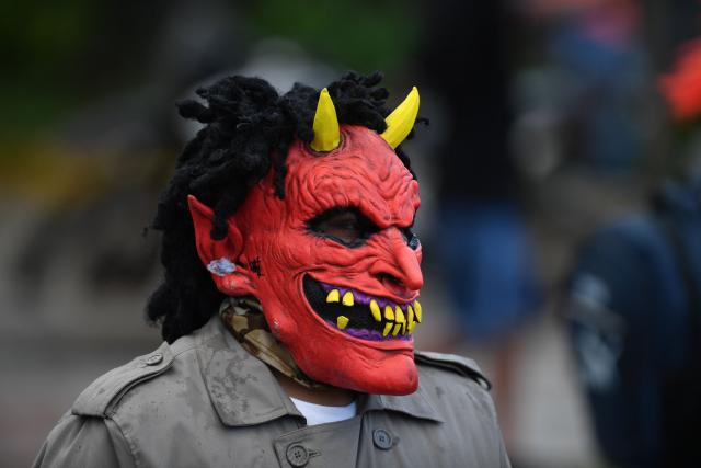 A masked resident walks along a street as part of a tradition after the Good Friday procession in Petoa, Santa Barbara department, Honduras, on April 3, 2026. (Photo by Orlando SIERRA / AFP)