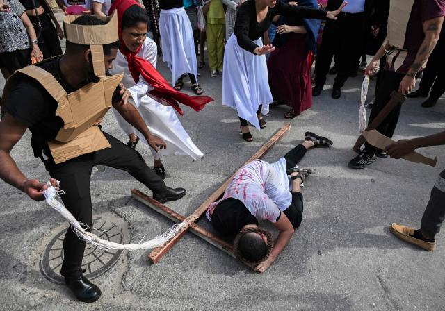 A man depicting Jesus falls while carrying a cross during a Way of the Cross procession on Good Friday, in Havana, on April 3, 2026. (Photo by YAMIL LAGE / AFP)