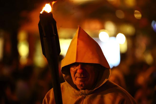 A Catholic faithful holds a torch as he takes part in the traditional Stations of the Cross procession, reenacting the final hours of Jesus Christ’s life, lighting up the streets with torches and candles in Gramado, Rio Grande do Sul state, Brazil on April 3, 2026. (Photo by SILVIO AVILA / AFP)
