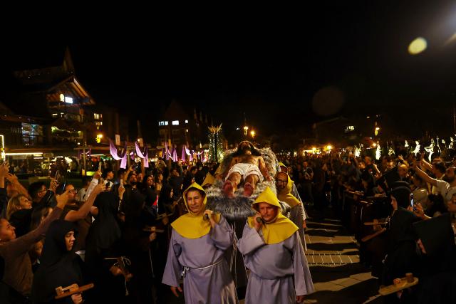 Catholic faithful take part in the traditional Stations of the Cross procession, reenacting the final hours of Jesus Christ’s life, lighting up the streets with torches and candles in Gramado, Rio Grande do Sul state, Brazil on April 3, 2026. (Photo by SILVIO AVILA / AFP)