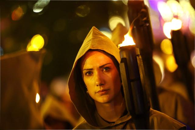 A Catholic faithful holds a torch as she takes part in the traditional Stations of the Cross procession, reenacting the final hours of Jesus Christ’s life, lighting up the streets with torches and candles in Gramado, Rio Grande do Sul state, Brazil on April 3, 2026. (Photo by SILVIO AVILA / AFP)