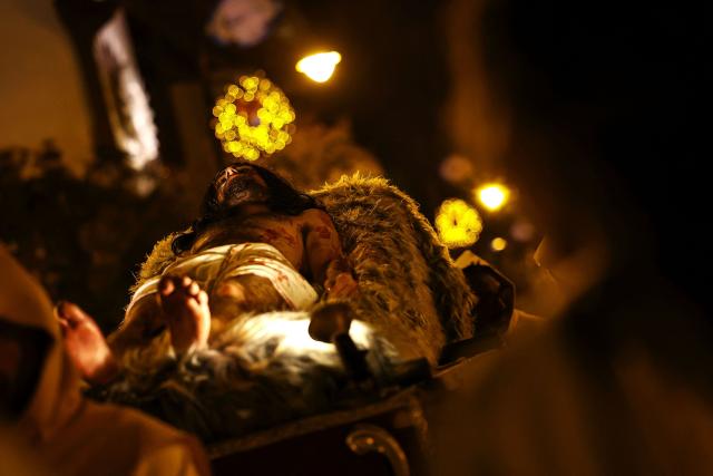 A Catholic faithful enacts the Passion of Jesus Christ as he takes part in the traditional Stations of the Cross procession, reenacting the final hours of Jesus Christ’s life, lighting up the streets with torches and candles in Gramado, Rio Grande do Sul state, Brazil on April 3, 2026. (Photo by SILVIO AVILA / AFP)