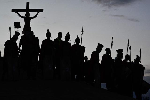 Catholic faithful enact the Passion of Jesus Christ as they take part in Via Crucis (Way of the Cross) on Good Friday at the Petare neighborhood in Caracas on April 3, 2026. (Photo by Maryorin Mendez / AFP)