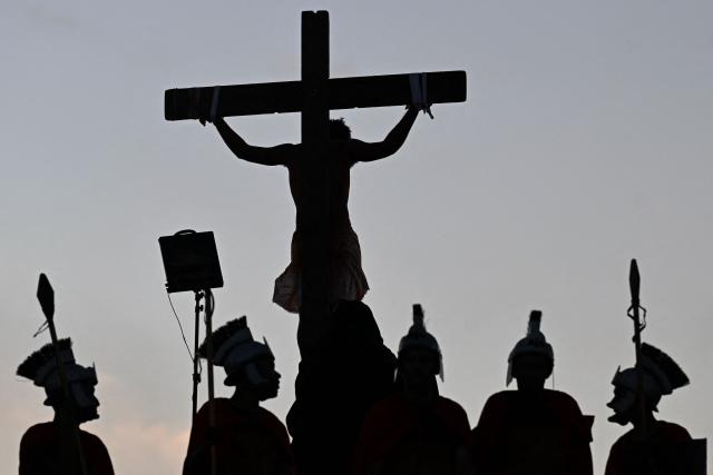 Catholic faithful enact the Passion of Jesus Christ as they take part in Via Crucis (Way of the Cross) on Good Friday at the Petare neighborhood in Caracas on April 3, 2026. (Photo by Maryorin Mendez / AFP)