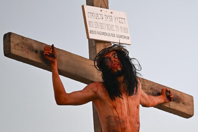 A Catholic faithful enacts the Passion of Jesus Christ as he takes part in Via Crucis (Way of the Cross) on Good Friday at the Petare neighborhood in Caracas on April 3, 2026. (Photo by Juan BARRETO / AFP)