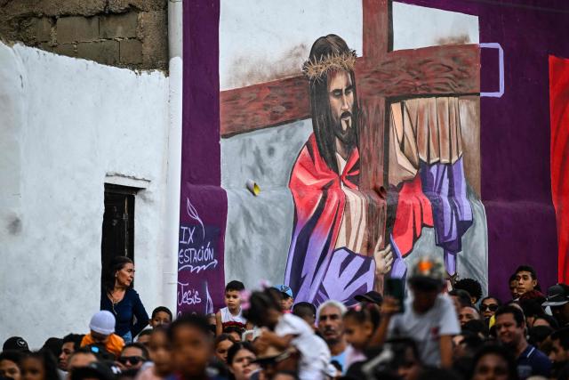 A mural depicting Jesus Christ is seen on a wall while Catholic faithful take part in Via Crucis (Way of the Cross) on Good Friday in the Petare neighborhood in Caracas on April 3, 2026. (Photo by Maryorin Mendez / AFP)