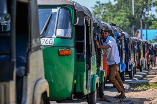 Drivers wait in a queue to refuel their auto rickshaws at a fuel station in Biyagama on the outskirts of Colombo on March 15, 2026. Sri Lanka is struggling to prevent a repeat of its spectacular economic collapse four years ago, as the prolonged Middle East war compounds the fallout from a deadly cyclone in November. (Photo by Ishara S. KODIKARA / AFP)