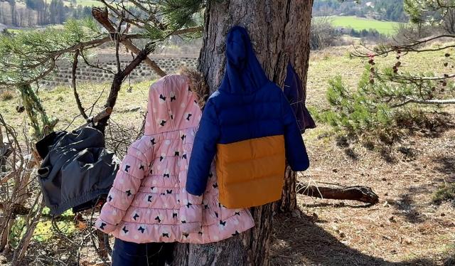 A photo shows the coats of kindergarten pupils hanging on a trees as they attend a class outside in Sederon, southern France, on March 13, 2026. Just like every Friday morning, the fourteen children in the combined kindergarten-first-grade class at the public school in Sйderon make their way up a hill overlooking the village. They’re heading out for outdoor learning. (Photo by Guillaume BONNET / AFP)
