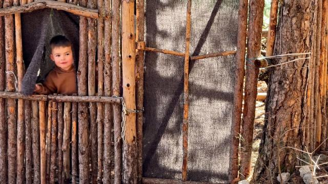 A kindergarten pupil looks out from a cabin during a class held outside in Sederon, southern France, on March 13, 2026. Just like every Friday morning, the fourteen children in the combined kindergarten-first-grade class at the public school in Sйderon make their way up a hill overlooking the village. They’re heading out for outdoor learning. (Photo by Guillaume BONNET / AFP)