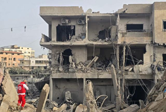A rescue worker inspects the debris of destroyed buildings at the site of an Israeli strike in the southern Lebanese area of Maarakeh near the coastal city of Tyre on April 4, 2026. The Israeli military said on April 3, it had struck more than 3,500 targets across Lebanon in the month since fighting with Iran-backed Hezbollah militants. Lebanon was drawn into the Middle East war on March 2 when Hezbollah launched attacks on Israel to avenge the killing of the Iranian leader. Israel has responded with broad strikes across Lebanon and a ground offensive. (Photo by Kawnat HAJU / AFP)