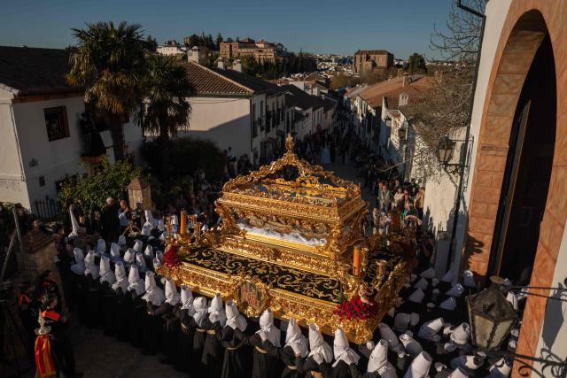 TOPSHOT - Penitents of the “Santo Entierro de Cristo” brotherhood bear a float with a statue of Christ in a coffin during the Good Friday procession in Ronda on April 3, 2026. Christian believers around the world mark the Holy Week of Easter in celebration of the crucifixion and resurrection of Jesus Christ. (Photo by JORGE GUERRERO / AFP)