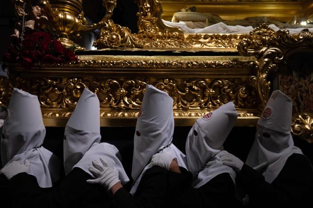Penitents of the “Santo Entierro de Cristo” brotherhood bear a float with a statue of Christ in a coffin during the Good Friday procession in Ronda on April 3, 2026. Christian believers around the world mark the Holy Week of Easter in celebration of the crucifixion and resurrection of Jesus Christ. (Photo by JORGE GUERRERO / AFP)
