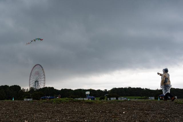 A man flies a kite on a beach at Kasai Rink park as a large storm moves over Tokyo on April 4, 2026. (Photo by ANDREW CABALLERO-REYNOLDS / AFP)