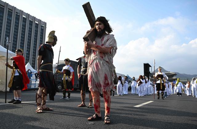 Participants in costumes take part in an Easter parade at Gwanghwamun Square in Seoul on April 4, 2026. (Photo by Jung Yeon-je / AFP)