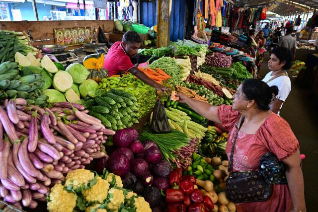 A vendor sells vegetables at a market in Colombo on April 2, 2026. President Anura Kumara Dissanayake has rationed fuel, raised its price by a third and increased electricity tariffs by up to 40 percent since the Middle East war disrupted global energy supplies. (Photo by Ishara S. KODIKARA / AFP)