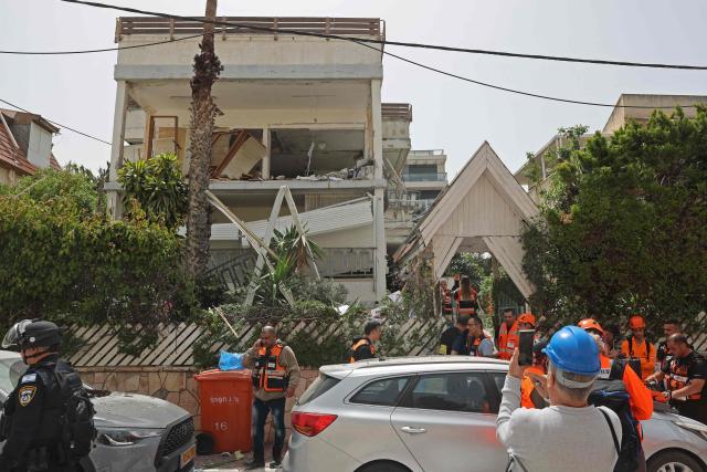 Israeli security forces and first responders gather at the site of an Iranian strike that hit a residential neighbourhood in Ramat Gan on April 4, 2026. The Israeli army said on April 4 its air defences were working to down missiles fired from Iran, which medics reported wounded one person. (Photo by Jack GUEZ / AFP) / 