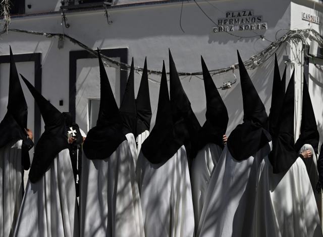 TOPSHOT - Penitents of the ‘El Cachorro’ brotherhood prepare to take part in Good Friday procession during Holy Week in Seville, on April 3, 2026. Christian believers around the world mark the Holy Week of Easter in celebration of the crucifixion and resurrection of Jesus Christ. (Photo by CRISTINA QUICLER / AFP)