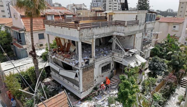 This aerial photograph shows Israel's first responders inspecting a building that was hit by an Iranian strike in a residential neighbourhood in Ramat Gan on April 4, 2026. The Israeli army said on April 4 its air defences were working to down missiles fired from Iran, which medics reported wounded one person. (Photo by Jack GUEZ / AFP) / 
