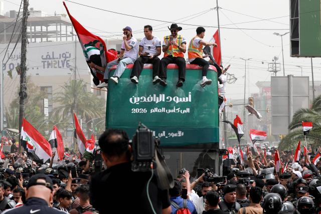 TOPSHOT - Members of Iraq's men's national football team sit atop a double-decker bus as they are paraded with fans in the Jadriya area of central Baghdad on April 4, 2026 to celebrate the country's qualification to the 2026 FIFA World Cup to be held in North America in the summer. The "Lions of Mesopotamia" secured the country's first World Cup appearance since the 1986 competition in Mexico with a 2-1 win over Bolivia late on March 31. The build-up to the match had been overshadowed by the outbreak of the Middle East war in late February, when the US and Israel attacked Iran, subsequently dragging Iraq into the conflict. (Photo by MURTAJA LATEEF / AFP)