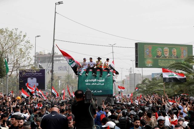 Members of the Iraq's men's national football team sit atop a double-decker bus as they are paraded with fans in the Jadriya area of central Baghdad on April 4, 2026 to celebrate the country's qualification to the 2026 FIFA World Cup to be held in North America in the summer. The "Lions of Mesopotamia" secured the country's first World Cup appearance since the 1986 competition in Mexico with a 2-1 win over Bolivia late on March 31. The build-up to the match had been overshadowed by the outbreak of the Middle East war in late February, when the US and Israel attacked Iran, subsequently dragging Iraq into the conflict. (Photo by MURTAJA LATEEF / AFP)