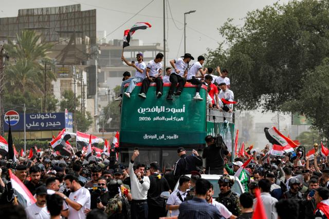 Members of the Iraq's men's national football team sit atop a double-decker bus as they are paraded with fans in the Jadriya area of central Baghdad on April 4, 2026 to celebrate the country's qualification to the 2026 FIFA World Cup to be held in North America in the summer. The "Lions of Mesopotamia" secured the country's first World Cup appearance since the 1986 competition in Mexico with a 2-1 win over Bolivia late on March 31. The build-up to the match had been overshadowed by the outbreak of the Middle East war in late February, when the US and Israel attacked Iran, subsequently dragging Iraq into the conflict. (Photo by MURTAJA LATEEF / AFP)