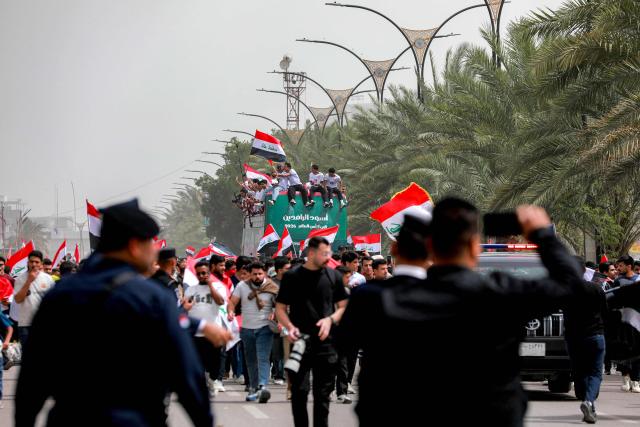 Members of Iraq's men's national football team sit atop a double-decker bus as they are paraded with fans in the Jadriya area of central Baghdad on April 4, 2026 to celebrate the country's qualification to the 2026 FIFA World Cup to be held in North America in the summer. The "Lions of Mesopotamia" secured the country's first World Cup appearance since the 1986 competition in Mexico with a 2-1 win over Bolivia late on March 31. The build-up to the match had been overshadowed by the outbreak of the Middle East war in late February, when the US and Israel attacked Iran, subsequently dragging Iraq into the conflict. (Photo by MURTAJA LATEEF / AFP)