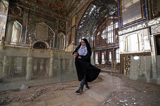 A visitor walks through the damaged interiors of the historic Golestan Palace in Tehran on April 4, 2026. Since the start of the war, a senior Tehran cultural official said US and Israeli strikes have damaged at least 120 museums and cultural and historic sites nationwide, including the capital's UNESCO-listed Golestan Palace -- sometimes likened to Versailles. The palace complex is one of the oldest sites in the Iranian capital and once served as the residence of the Qajar dynasty. (Photo by ATTA KENARE / AFP) / 