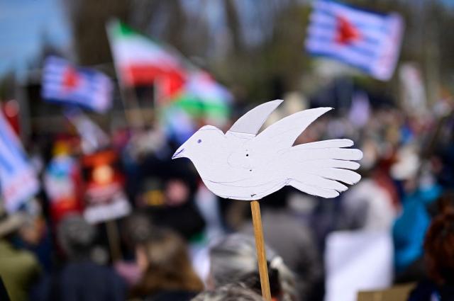 A cardboard dove is held by a protester during an Easter March Peace demonstration organised by the Berlin Peace Coordination (FRIKO) in Berlin, on April 4, 2026. (Photo by Tobias SCHWARZ / AFP)