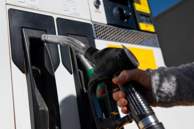 (FILES) A woman takes a pump to fill up her car's petrol tank at a gas station in Ronda, near Malaga on March 11, 2026. Spain and four other European Union nations have called for a tax on windfall profits of energy companies in response to rising fuel prices due to the Middle East war, Spanish Economy Minister said on April 4, 2026. (Photo by JORGE GUERRERO / AFP)