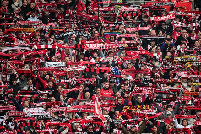 Freiburg fans display their scarves prior to the German first division Bundesliga football match between SC Freiburg and FC Bayern Munich in Freiburg, southern Germany on April 4, 2026. (Photo by Silas STEIN / AFP) / DFL REGULATIONS PROHIBIT ANY USE OF PHOTOGRAPHS AS IMAGE SEQUENCES AND/OR QUASI-VIDEO