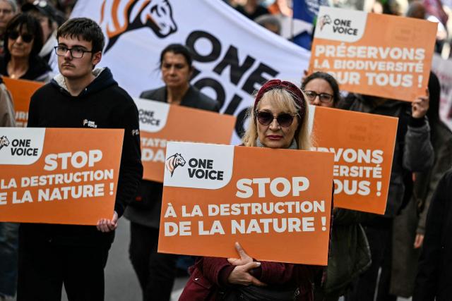 Protesters with placards which read "Stop the destruction of nature" take part in the rally 'Marche Printemps Bruyant 2026', a mobilization against the use of pesticides, just a few days before World Health Day, in Paris on April 4, 2026. (Photo by Anna KURTH / AFP)