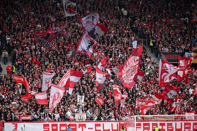 Freiburg fans wave flags prior to the German first division Bundesliga football match between SC Freiburg and FC Bayern Munich in Freiburg, southern Germany on April 4, 2026. (Photo by Silas STEIN / AFP) / DFL REGULATIONS PROHIBIT ANY USE OF PHOTOGRAPHS AS IMAGE SEQUENCES AND/OR QUASI-VIDEO