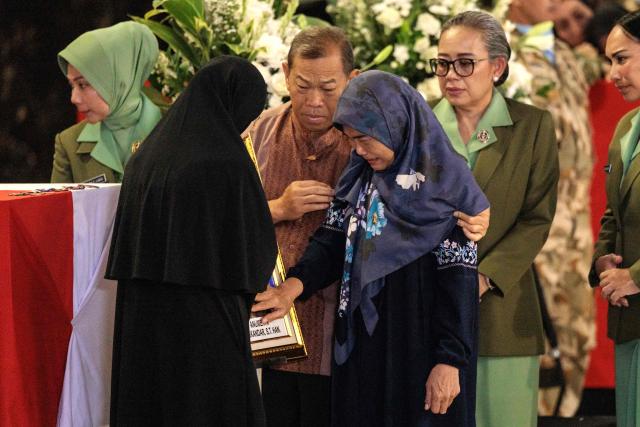 Family members of Indonesian soldier Zulmi Aditya Iskandar, who was killed while serving with the United Nations Interim Force in Lebanon (UNIFIL) in southern Lebanon, mourn beside his coffin as the coffins of three Indonesian soldiers arrive at Soekarno-Hatta International Airport in Tangerang on April 4, 2026. Indonesia received the bodies of three peacekeepers on April 4 who were killed while on deployment in Lebanon and called for security guarantees for blue helmets a day after another three of its soldiers were injured. (Photo by Yasuyoshi CHIBA / AFP)