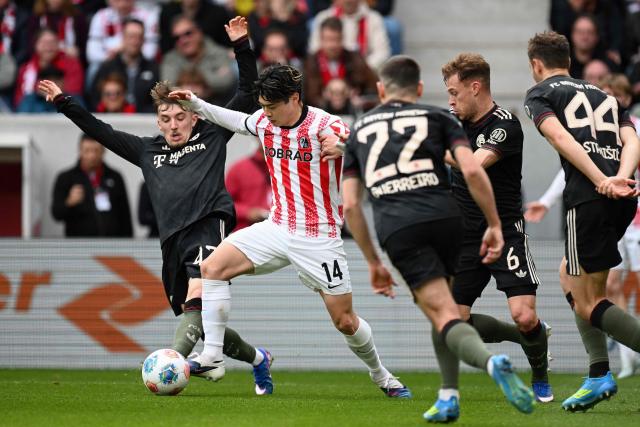 Bayern Munich's German midfielder #42 Lennart Karl (L) and Freiburg's Japanese midfielder #14 Yuito Suzuki vie for the ball during the German first division Bundesliga football match between SC Freiburg and FC Bayern Munich in Freiburg, southern Germany on April 4, 2026. (Photo by Silas STEIN / AFP) / DFL REGULATIONS PROHIBIT ANY USE OF PHOTOGRAPHS AS IMAGE SEQUENCES AND/OR QUASI-VIDEO