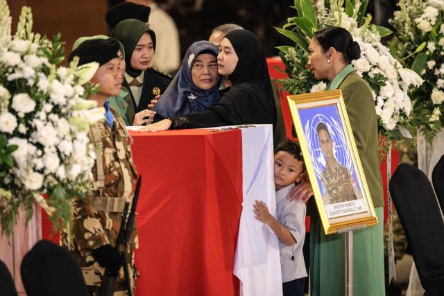 Family members of Indonesian soldier Zulmi Aditya Iskandar, who was killed while serving with the United Nations Interim Force in Lebanon (UNIFIL) in southern Lebanon, mourn beside his coffin as the coffins of three Indonesian soldiers arrive at Soekarno-Hatta International Airport in Tangerang on April 4, 2026. Indonesia received the bodies of three peacekeepers on April 4 who were killed while on deployment in Lebanon and called for security guarantees for blue helmets a day after another three of its soldiers were injured. (Photo by Yasuyoshi CHIBA / AFP)