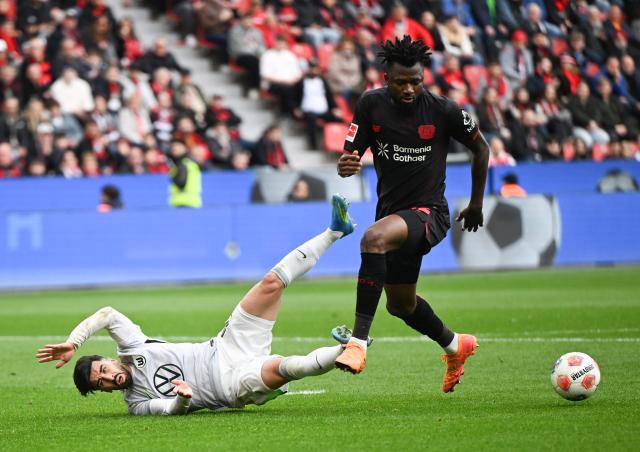 Wolfsburg's Algerian forward #09 Mohammed Amoura (L) is fouled by Bayer Leverkusen's Burkinabe defender #12 Edmond Tapsoba during the German first division Bundesliga football match between Bayer leverkusen and VfL Wolfsburg in Leverkusen on April 4, 2026. (Photo by INA FASSBENDER / AFP) / DFL REGULATIONS PROHIBIT ANY USE OF PHOTOGRAPHS AS IMAGE SEQUENCES AND/OR QUASI-VIDEO