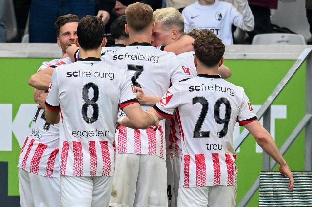Freiburg's Swiss midfielder #44 Johan Manzambi (hidden) celebrates scoring the opening goal with his teammates during the German first division Bundesliga football match between SC Freiburg and FC Bayern Munich in Freiburg, southern Germany on April 4, 2026. (Photo by Silas STEIN / AFP) / DFL REGULATIONS PROHIBIT ANY USE OF PHOTOGRAPHS AS IMAGE SEQUENCES AND/OR QUASI-VIDEO