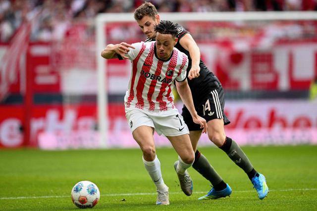Freiburg's German forward #07 Derry Scherhant and Bayern Munich's Croatian defender #44 Josip Stanisic vie for the ball during the German first division Bundesliga football match between SC Freiburg and FC Bayern Munich in Freiburg, southern Germany on April 4, 2026. (Photo by Silas STEIN / AFP) / DFL REGULATIONS PROHIBIT ANY USE OF PHOTOGRAPHS AS IMAGE SEQUENCES AND/OR QUASI-VIDEO